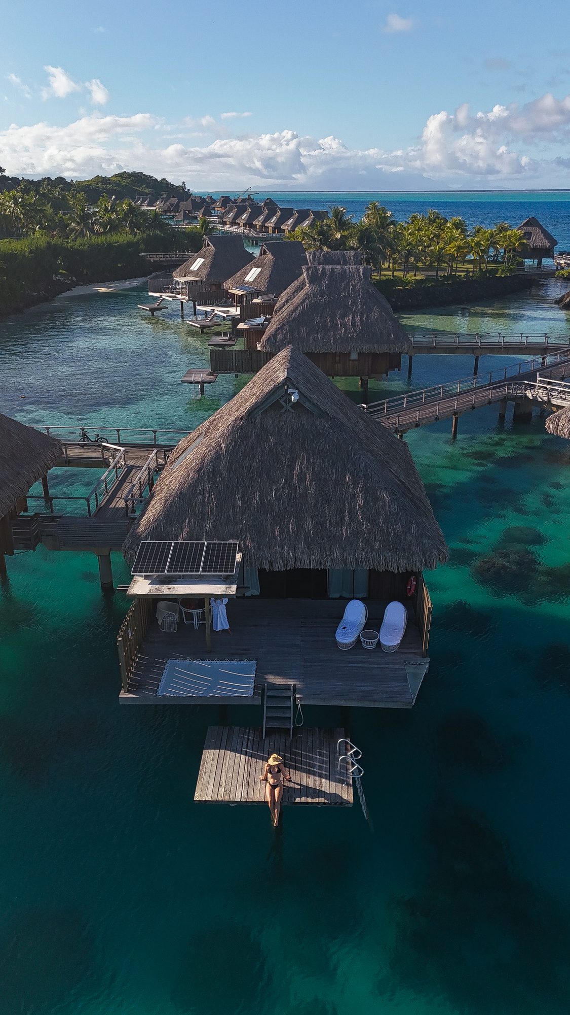 An overwater resort in the tropics surrounded by turquoise water